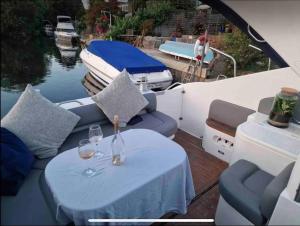 una mesa en un barco con copas de vino. en Lux 8Br Thamesfront Villa w Yacht & Sauna, en Staines