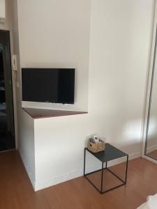 a living room with a flat screen tv on a wall at Charmant Studio au coeur de Castanet-Tolosan in Castanet-Tolosan