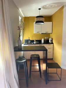 a small kitchen with a table and two stools at Charmant Studio au coeur de Castanet-Tolosan in Castanet-Tolosan