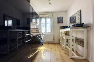 a kitchen with wooden floors and black counter tops at Ohana in Deauville