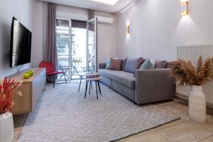 a living room with a couch and a tv at Stylish 2BDR Exarchia Apt with Balcony and Workspace in Athens