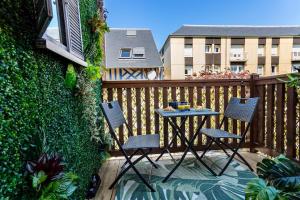 a patio with three chairs and a table on a balcony at Ohana in Deauville