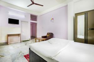 a white bedroom with a bed and a ceiling fan at GREEN VISTA HOMESTAY in Guwahati