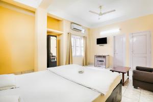 a room with two beds and a couch and a tv at GREEN VISTA HOMESTAY in Guwahati