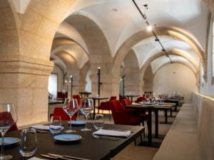 a restaurant with tables and chairs and wine glasses at MS Collection Arouca - Mosteiro de Arouca in Arouca