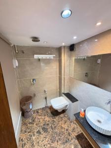 a bathroom with a toilet and a sink at Hotel Cozzy Palace in Surat +20 photos