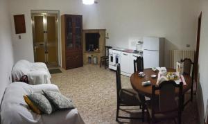 a living room with a table and a kitchen at Casa Cucchiara in Grottaglie