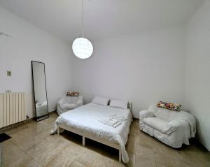 a white room with a bed and a couch at Casa Cucchiara in Grottaglie