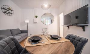 ein Wohnzimmer mit Tisch und Couch in der Unterkunft La Citadine in Chalon-sur-Saône