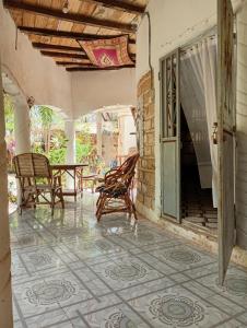 an outdoor patio with rocking chairs and a table at Guesthouse JUNGLE & OCÉAN ABÉNÉ in Abémé