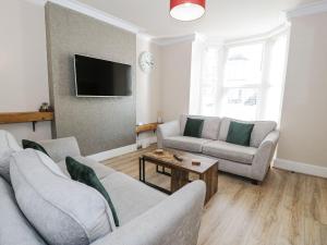 a living room with two couches and a tv at Llandudno 3 Bedroom Holiday Apartment in Town Centre in Llandudno