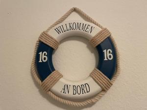 a wreath on a wall with the words willushima an bond at Ferienwohnung Sibirian Husky in Thiessow +11 photos