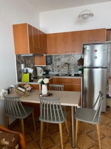 a kitchen with a table and a stainless steel refrigerator at Haraki Dream View in Haraki