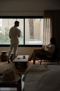 a man and a woman standing in a living room at Hotel Anilevich Mansion in Beer Sheva