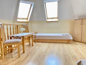 a bedroom with a bed and a table and two windows at Podlesie in Ostrowo +37 photos