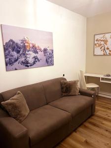 - un salon doté d'un canapé brun dans l'établissement DOLOMIA APARTMENTS PINZOLO vicino alle funivie, à Pinzolo