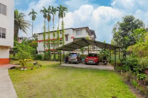 two cars parked under a tent in front of a house at GREEN VISTA HOMESTAY in Guwahati