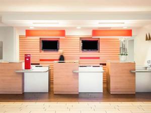 un vestíbulo con una mujer de pie en el fondo en Hotel Ibis Milano Malpensa, en Cardano al Campo