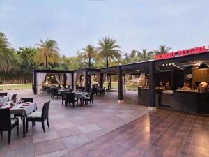a restaurant with tables and chairs on a patio at Novotel Hyderabad Convention Centre in Hyderabad