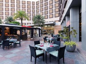 a restaurant with tables and chairs in front of a building at Novotel Hyderabad Convention Centre in Hyderabad