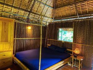 a bedroom with a bed in a straw hut at Homestay Mekong Can Tho in Can Tho