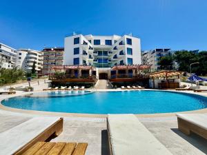 a large swimming pool in front of a building at Harbour Hotel in Sarandë