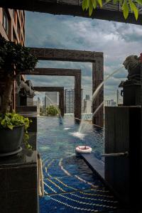 a swimming pool with a fountain in the middle of a city at Siam@Siam, Design Hotel Bangkok in Bangkok