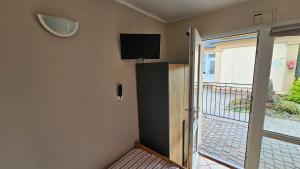 a room with a balcony with a tv on the wall at RIVA Ośrodek Wypoczynkowy in Więcbork