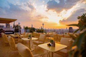 a rooftop restaurant with tables and chairs at sunset at Siam@Siam, Design Hotel Bangkok in Bangkok