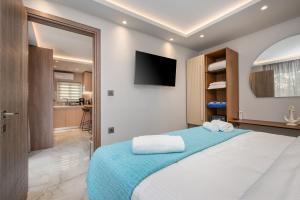 a bedroom with a large bed with a flat screen tv at Diamante Del Mar Crete Rhodes in Kos