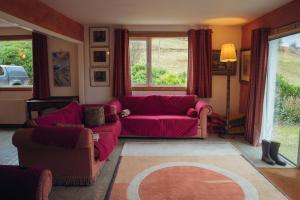 a living room with a red couch and chairs at Ardtalnaig House, Loch Tay in Ardtalnaig