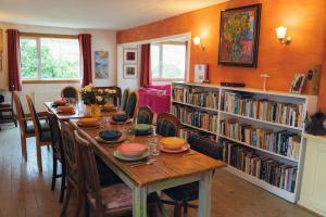 a dining room with a table and a book shelf at Ardtalnaig House, Loch Tay in Ardtalnaig
