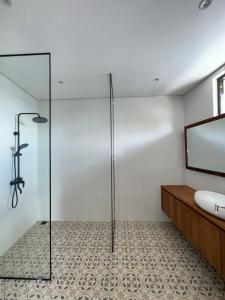 a bathroom with a glass shower and a sink at Tuluscoliving Villa in Ngurah Rai International Airport