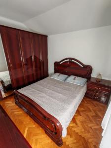 a bedroom with a wooden bed and a wooden dresser at Diego in Rijeka
