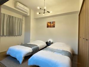 Un dormitorio con dos camas y un techo. en APATEL Shinsaibashi, en Osaka