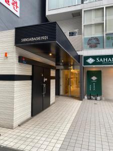 una entrada a un edificio con una puerta giratoria en APATEL Shinsaibashi, en Osaka