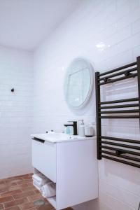 a bathroom with a white sink and a mirror at Mar-Ria 6 in Fuzeta