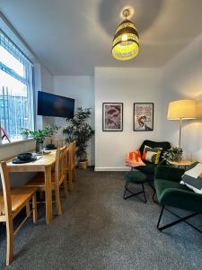 a living room with a table and a dining room at Wigan 1BR Haven - Perfect for a Relaxing Stay in Wigan