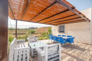 a patio with a table and chairs and a wooden pergola at Casa rural Acueducto in Almería