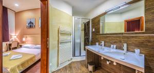 a bathroom with a sink and a bed and a mirror at Budapest Citi Guesthouse - contactless self check in in Budapest +24 photos