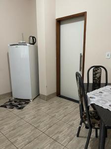 a dining room with a table and a refrigerator at Apartamento próximo ao centro in Primavera do Leste