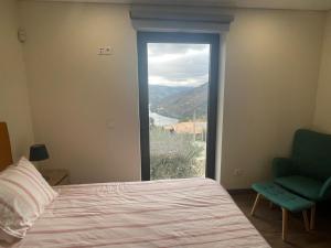 una camera da letto con un letto, una sedia e una finestra di Quinta do Casal Bystol, Casa 1 a Casal de Loivos Altre 47 foto