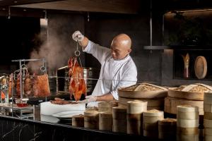 a chef preparing food in a restaurant kitchen at InterContinental Bangkok by IHG in Bangkok