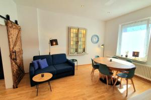 a living room with a blue couch and a table at FRANKES SLEEP INN, 4, 2, 1 Raumwohnungen, Sauna in Velbert