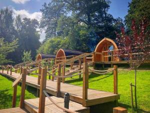 a wooden deck with a playground in a park at Mountain Edge Resort Lodge 3 with Hot Tub in Church Stretton