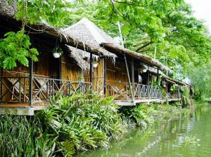 a wooden house with a bridge over a river at Homestay Mekong Can Tho in Can Tho