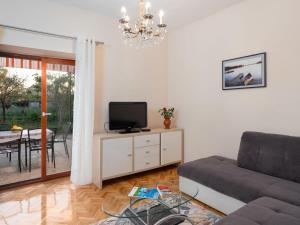 a living room with a couch and a tv at Holiday Home Marijana by Interhome in Sukošan