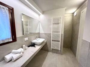 Holiday Home Ville Rio-1 by Interhome في لينانو سابيادورو: حمام أبيض مع حوض ومرآة