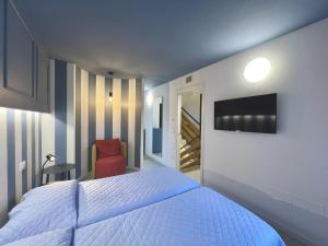 Holiday Home Ville Rio-1 by Interhome في لينانو سابيادورو: غرفة نوم بسرير وتلفزيون وكرسي