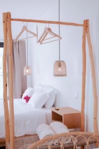 a bedroom with a white bed with a wooden swing at Mar-Ria 7 in Fuzeta